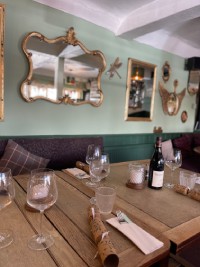 A beautifully arranged table featuring several wine glasses and a bottle of wine, perfect for a gathering or celebration